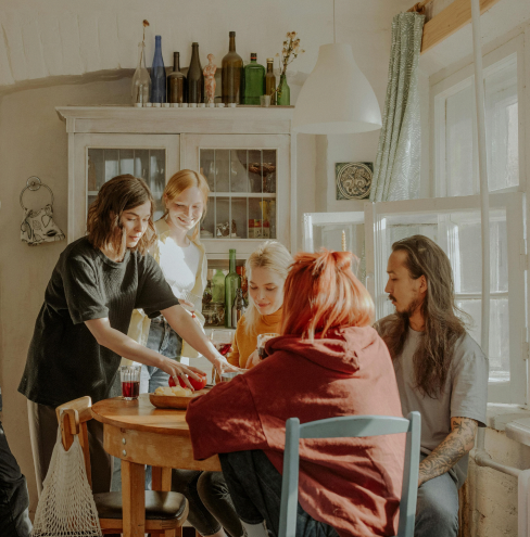 Jeunes colocataires partageant un repas dans une cuisine rustique